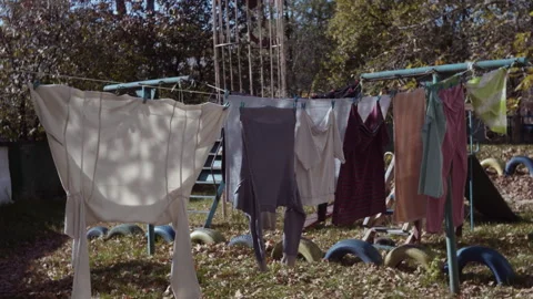 Clean washed linen hangs in the yard in the summer sun Video stock 253223899