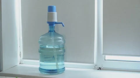 Clean washed plastic bottle of 19 liters, windowsill white background window  Vídeo Stock 239610824