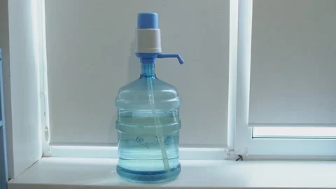 Clean washed plastic bottle of 19 liters, windowsill white background window  Stock-Footage 239610825