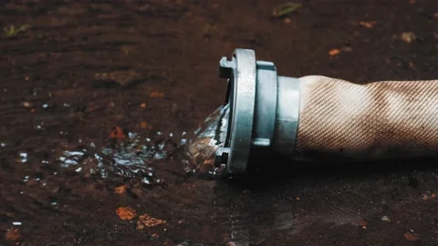 Clean Water Flowing Out of Polyester Fire Hose with Metal Aluminum Coupler Stock Footage 159510188