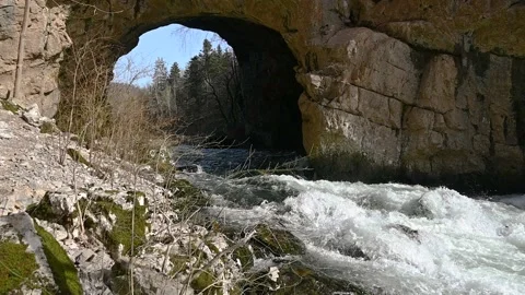 Clean water flowing under big natural bridge of Rakov Skocjan Stock Footage 150397217