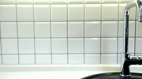 Clean water flows from metal tap in bathroom in apartment. Video stock 82158231