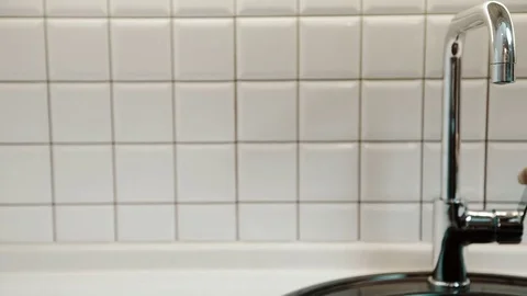 Clean water flows from silver tap in bathroom indoors. Video stock 82359743