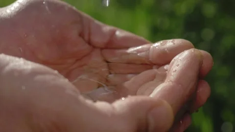 Clean water in human hands. stream of pure water pouring into male hands. water Stock Footage 132789902