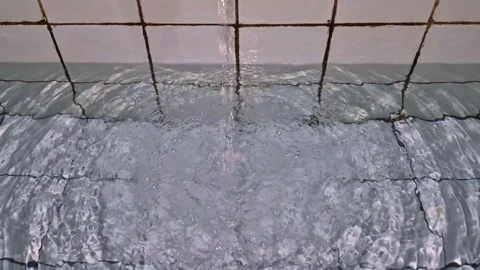 Clean water pouring into a white tiled bathtub Stock Footage 337792090