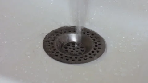 Clean Water Running Down the Metal Drain in a White Porcelain Bathroom Sink Stock Footage 337421582