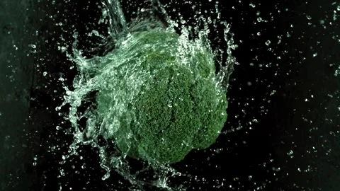 Clean water stream falling on fresh green broccoli on black background slow.. Stock Footage 327573999