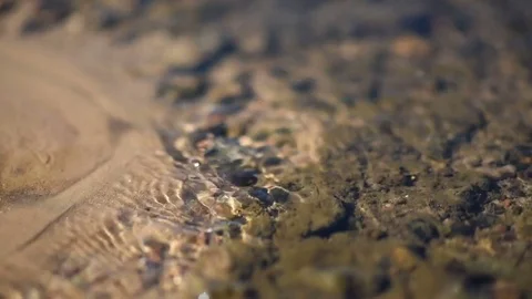 Clean water stream flows through the sand and glare in the sun Video stock 78929782