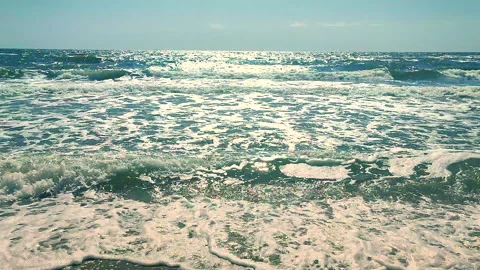 Clean waves sea with white foam sun glare rolling onto sandy beach of seashore Stock Footage 305776950