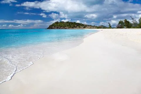 A clean white caribbean beach with deep blue sky and turquoise water. Stock Photos