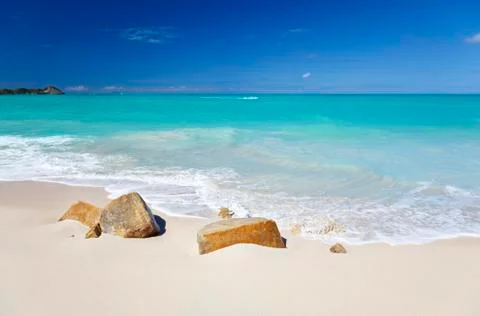 A clean white caribbean beach with deep blue sky and turquoise water, some st Stock Photos