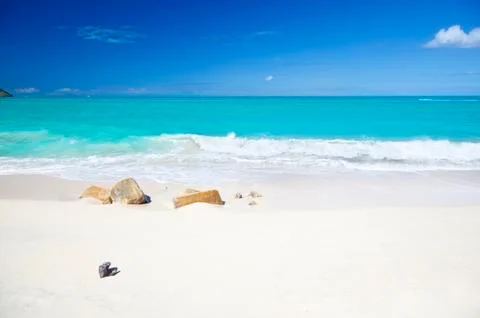 A clean white caribbean beach with deep blue sky and turquoise water, some st Stock Photos