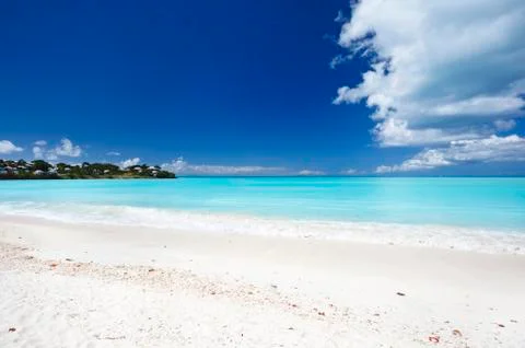 A clean white caribbean beach with deep blue sky and turquoise water. Stock Photos