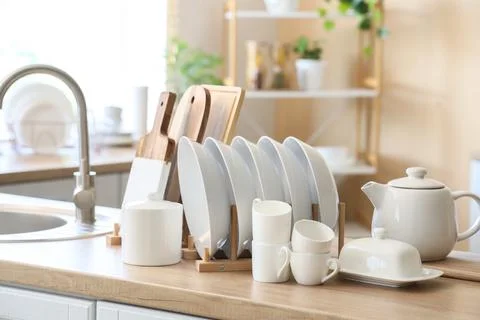 Clean white dishes and kitchenware on wooden countertop Stock Photos