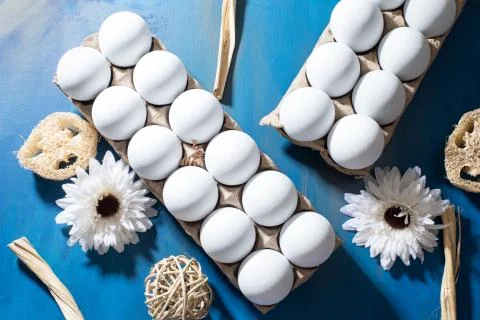 Clean white eggs on a deep blue background, flat lay Stock Photos