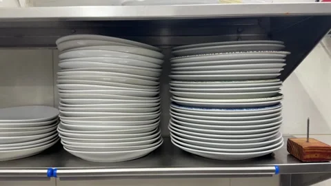 Clean white plates stacking on restaurant kitchen shelves 스톡 동영상 344100074