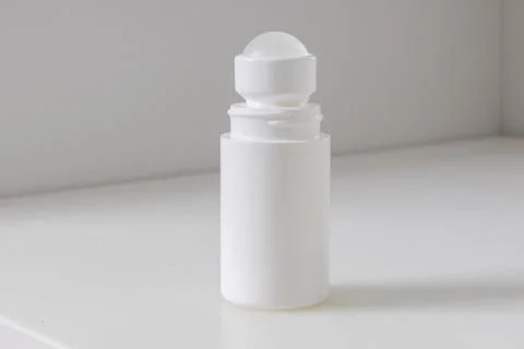 A clean white roll-on bottle standing upright on a light surface. Foto stock