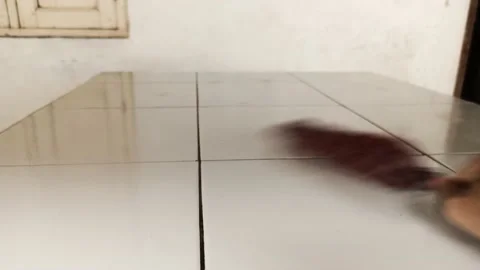Clean the white tile floor with a small duster Stock Footage 162354285