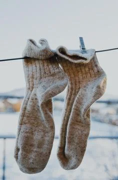 Clean woolen socks are put on the street in the courtyard of a village house. Stock Photos