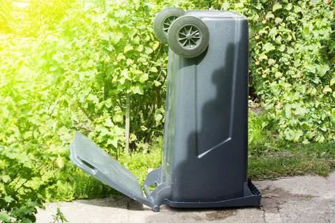 Cleaned grey garbage can is turned over and dries in sun light. Washing dumps Stock Photos