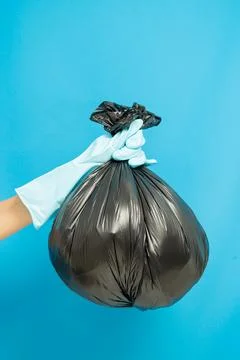 Cleaner concept, Hand in rubber gloves and holding plastic bag with trash was Stock Photos