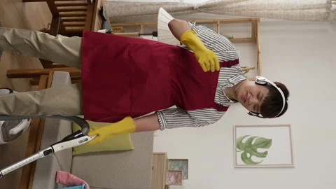 Cleaner man wearing headset is dancing to rhythm Video stock 229618098