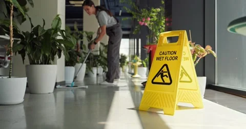 Cleaner Mopping Office Floor with Caution Wet Floor Sign, Professional Service Stock Footage 345837485