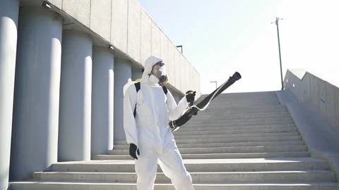 Cleaner with pressurized sprayer in hands going to disinfect public places Stock Footage 137759294