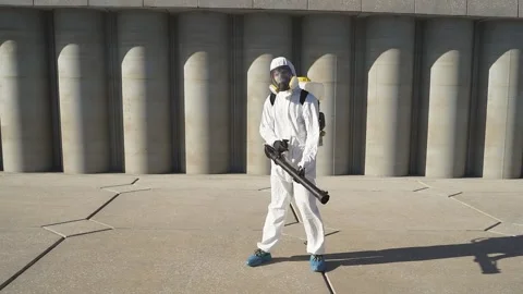 Cleaner with pressurized sprayer in hands going to disinfect public places. Stock Footage 137759528