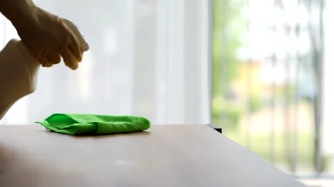Cleaner in protective yellow gloves sprinkles cleaning agent on the table Stock Footage 280316097