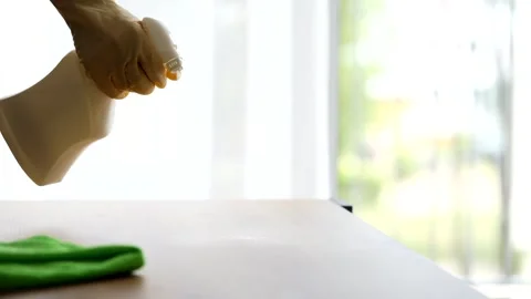 Cleaner in protective yellow gloves sprinkles cleaning agent on the table Stock Footage 280316141