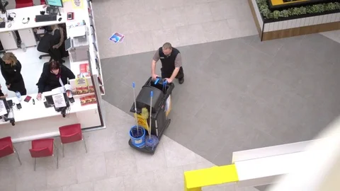 A cleaner is pushing his trolley in shopping centre. Stock Footage