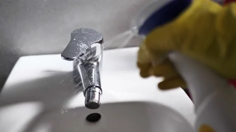 Cleaner sprays detergent on the tap. close up Stock Footage 150906036