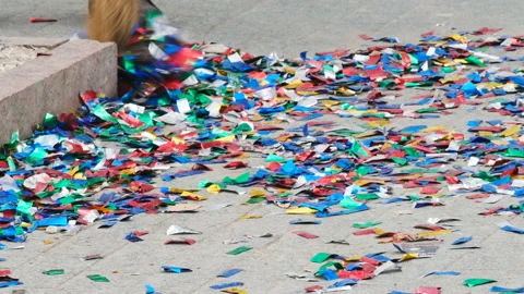 Cleaner sweeps bright colored confetti after party celebration Stock Footage