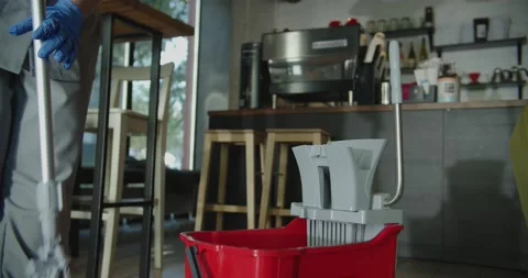 Cleaner work at the cafe. Squeeze mop in the bucket Stock Footage 138096439