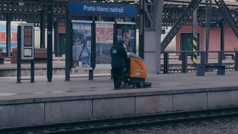 Cleaner is working on an empty platform on a railway station Stock Footage 85434733