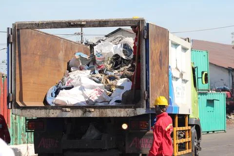 The cleaners are collecting garbage into the garbage truck Stock Photos