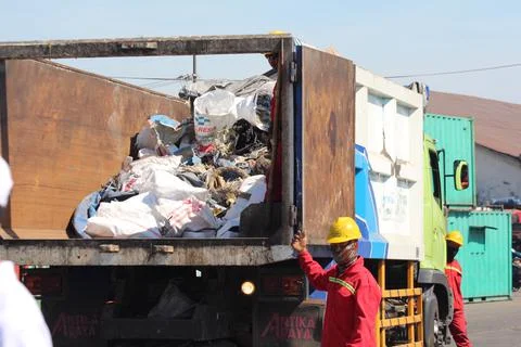 The cleaners are collecting garbage into the garbage truck 스톡 사진