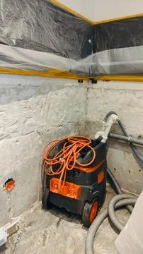 Cleaning after removing plaster to combat mold in the corner of a room with a Stock Photos