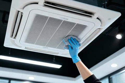 Cleaning an air conditioning unit with a microfiber cloth for maintenance Stock Photos