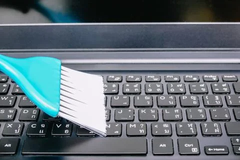 Cleaning and caring computer. cleaning the keyboard with a blue brush from dust Stock Photos