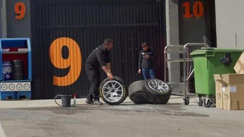 Cleaning and moving  ferrari racing tires. Racing tire crew. Stock Footage 105682764