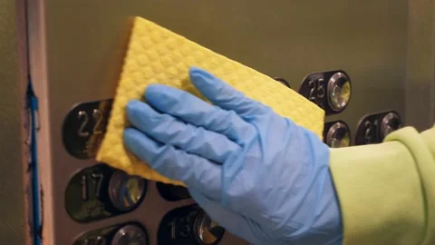 Cleaning and sanitizing an elevator push button control panel against bacteria Stock Footage 140458262