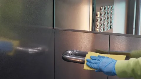 Cleaning and sanitizing an elevator push button control panel against bacteria Stock Footage 141448276