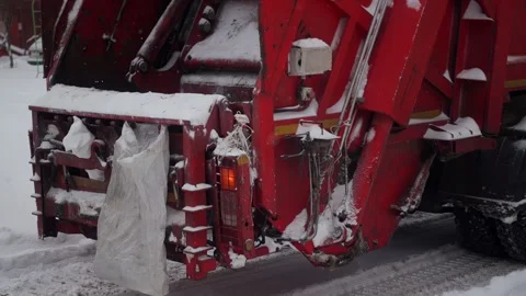 Cleaning and sorting garbage into a garbage truck in winter in the city. Slow Stock Footage 293684480