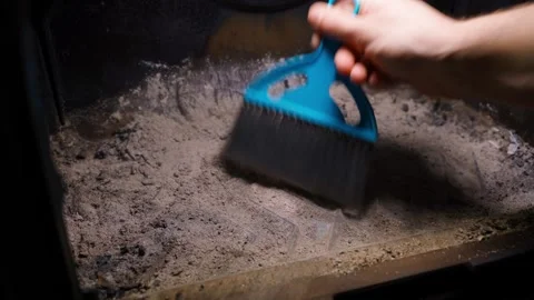 Cleaning the ashes in the fireplace with a small broom Stock Footage 324518458