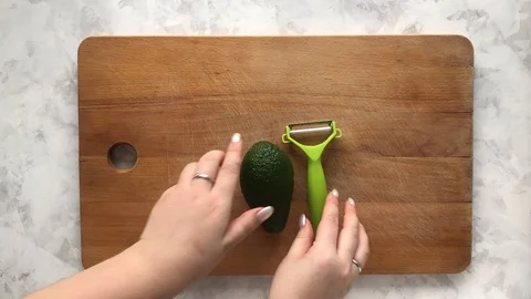 Cleaning avocado with a vegetable peeler Stock Footage 129181316