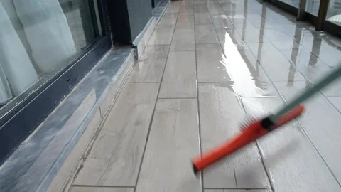 Cleaning Balcony Tiles with Squeegee After Washing with Water – Simple Outdoor Stock Footage 274894974