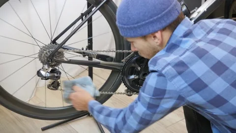 Cleaning bicycle chain with blue microfiber cloth. Regular common bike Stock Footage 161404574