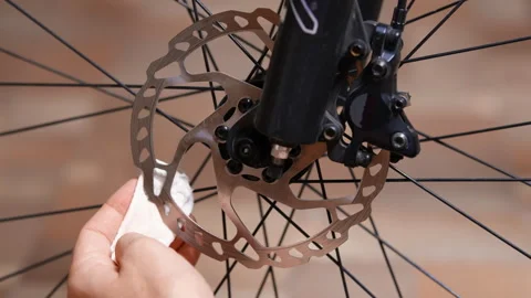 Cleaning a bicycle disc brake rotor with a special compound Stock Footage 280486865